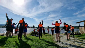 Eine hochmotivierte Gruppe beim Warm-Up für ein Floßbau Teamevent von bo events.