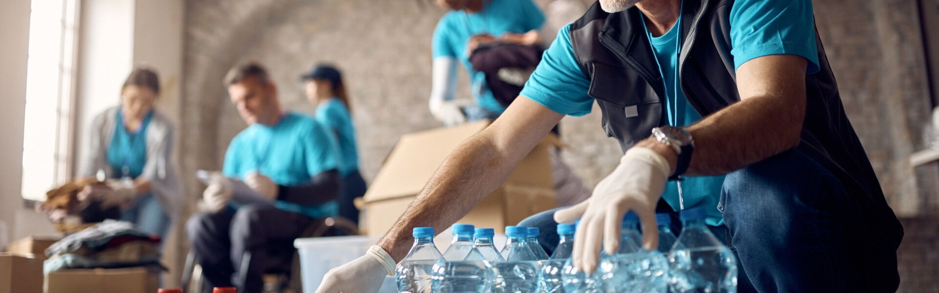 Freiwillige packen Essen und Trinken in Rationen zusammen.